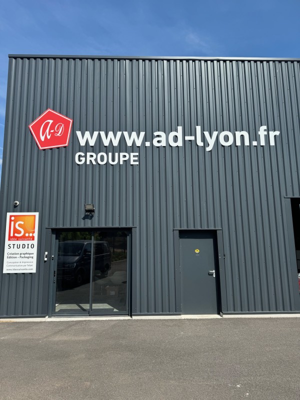 Pose d’une enseigne avec des lettres découpées en relief, collées sur une façade de bâtiment à Montmerle-sur-Saône
